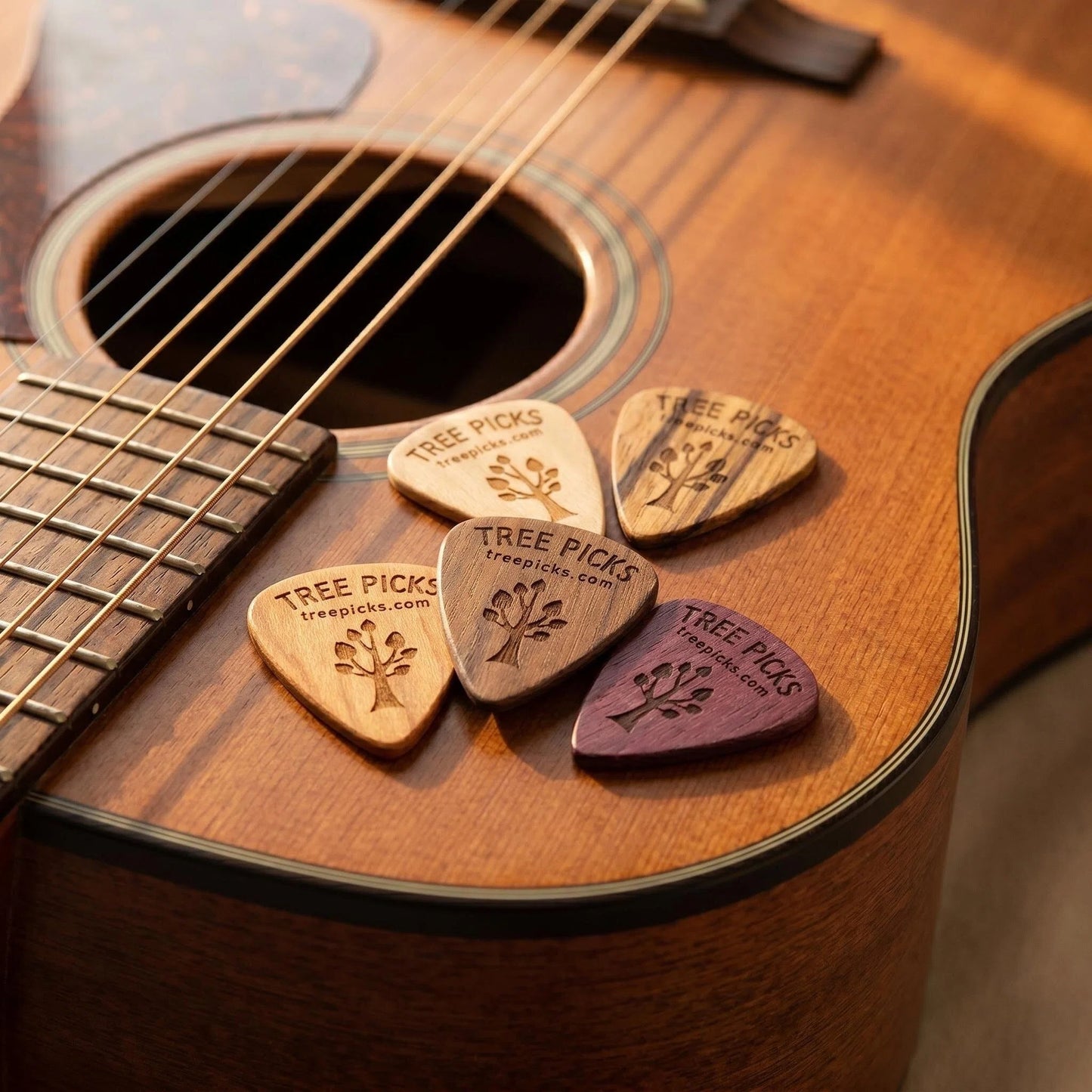 5 Tree Picks Wooden guitar picks on a acoustic guitar