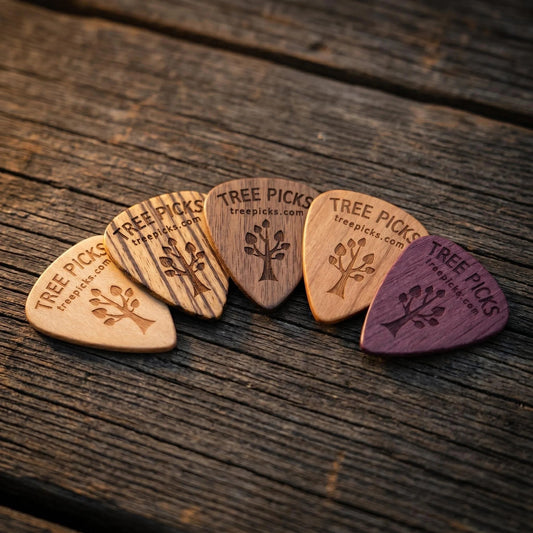 Set of wooden guitar picks with 'Tree Picks' branding on a rustic surface