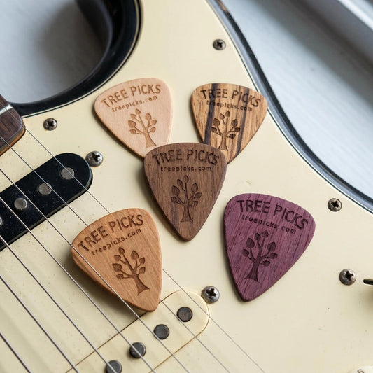 Wooden guitar picks with 'Tree Picks' branding on a electric guitar body.